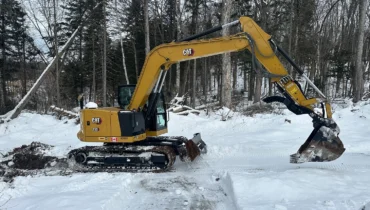 Homme sur une pelle excavatrice Caterpillar 10 tonnes travaillant à la construction d'un chemin privé